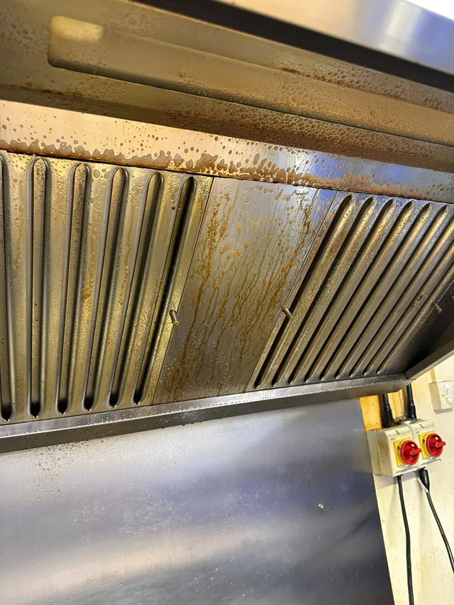 Hood filters and canopy before cleaning, covered in grease